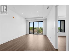 A spacious room with a sliding glass door leading to a balcony.