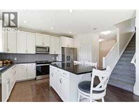 A kitchen with white cabinets and a black countertop.