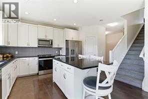 A kitchen with white cabinets and a black countertop.