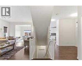 A real estate sign is on the wall of a spacious, well-lit room.