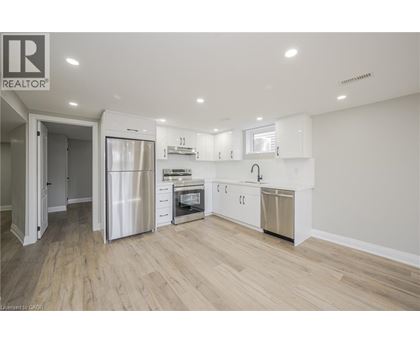 A modern kitchen with white cabinets and stainless steel appliances.