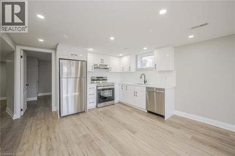 A modern kitchen with white cabinets and stainless steel appliances.