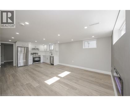 A spacious kitchen with white cabinets and a refrigerator.