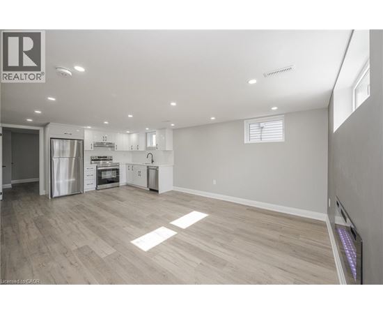 A spacious kitchen with white cabinets and a refrigerator.