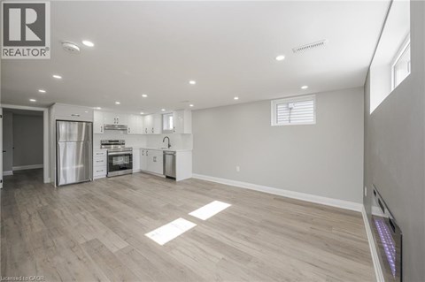 A spacious kitchen with white cabinets and a refrigerator.