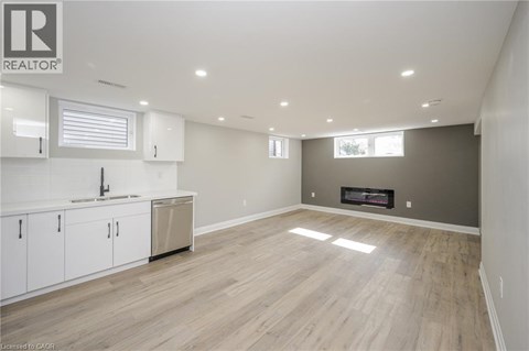 A spacious living room with a fireplace and hardwood flooring.