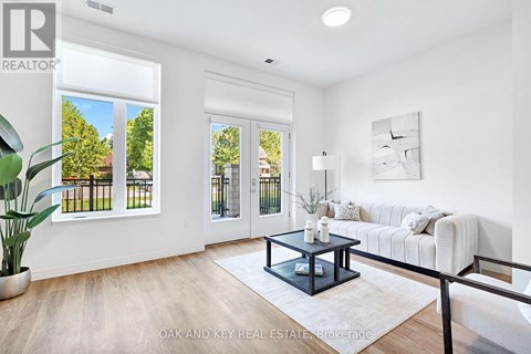 A living room with a white couch and a coffee table in the center.