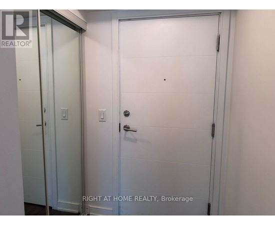 A white door with a handle and a small hole in the center of the door.