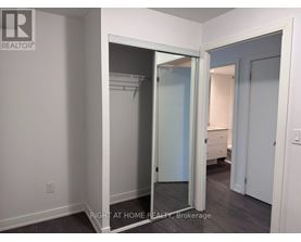 A brokerage sign is on the wall of a room with a closet.