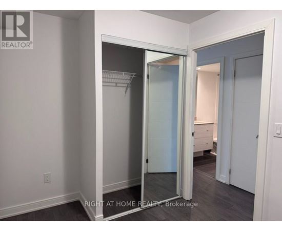 A brokerage sign is on the wall of a room with a closet.