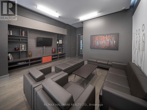 A modern living room with brown leather furniture and a painting on the wall.
