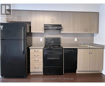 A kitchen with a black fridge, black oven and black dishwasher.