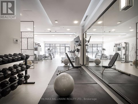 A gym with a variety of equipment including dumbbells, weights, and exercise balls.