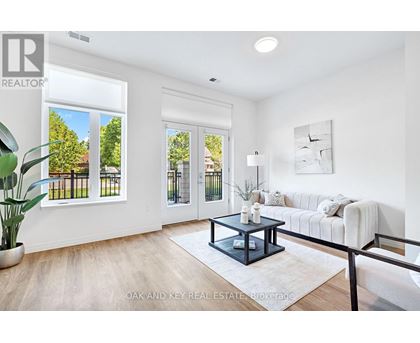 A living room with a white couch and a coffee table in the center.