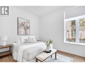 A bedroom with a large bed and a painting on the wall.