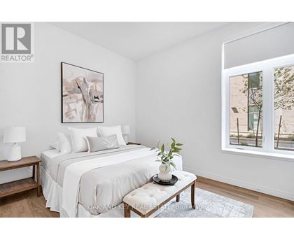 A bedroom with a large bed and a painting on the wall.