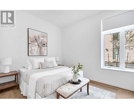 A bedroom with a large bed and a painting on the wall.