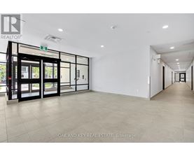 A spacious office with a glass door entrance and a tiled floor.