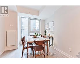 A dining room with a table set for two and a window letting in light.