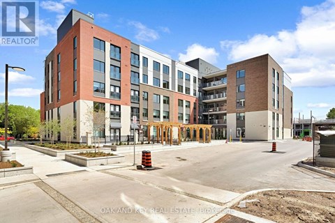 A modern building complex with a parking lot in front.