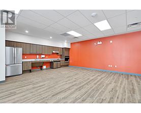 A large empty room with a wooden floor and orange walls.