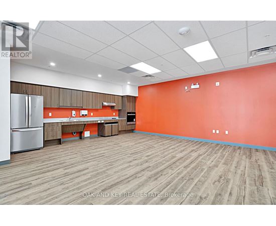 A large empty room with a wooden floor and orange walls.