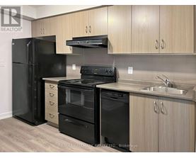 A kitchen with black appliances and wooden cabinets.