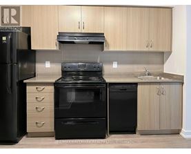 A kitchen with black appliances and wooden cabinets.