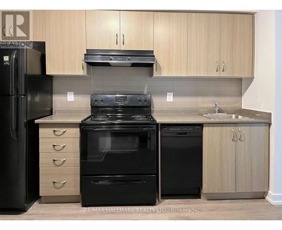 A kitchen with black appliances and wooden cabinets.