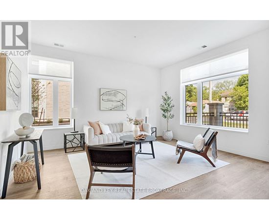 A living room with a white couch and a large window.