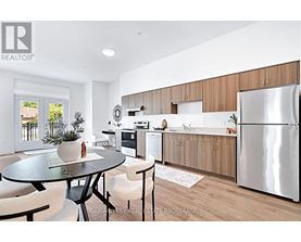 A modern kitchen with a glass table and chairs, a refrigerator, and wooden cabinets.