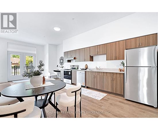 A modern kitchen with a glass table and chairs, a refrigerator, and wooden cabinets.