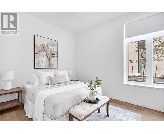 A bedroom with a large bed and a painting on the wall.