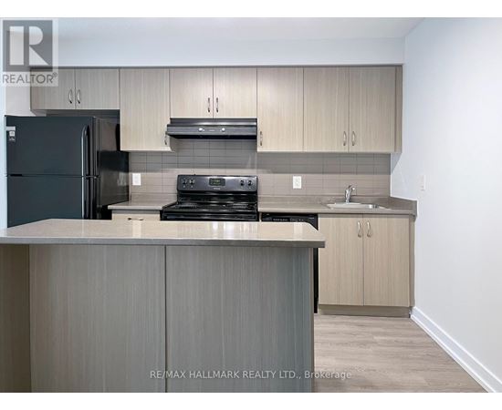 A kitchen with a black fridge, stove, and oven.