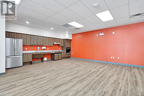 A large empty room with a wooden floor and orange walls.
