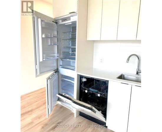 A white refrigerator with its door open in a kitchen.