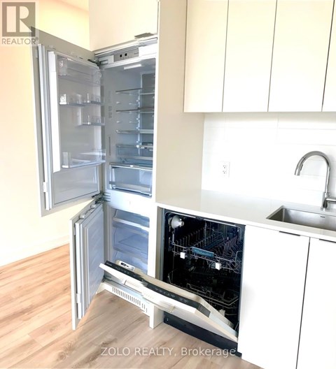 A white refrigerator with its door open in a kitchen.