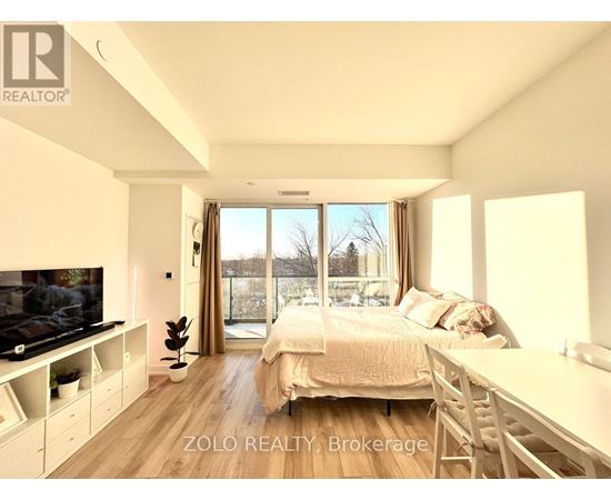 A bedroom with a large bed, a television, and a sliding glass door.
