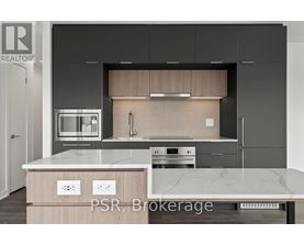 A modern kitchen with a marble countertop and stainless steel appliances.