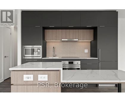 A modern kitchen with a marble countertop and stainless steel appliances.
