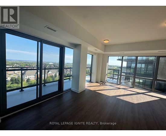 A spacious room with a view of the cityscape through large windows.