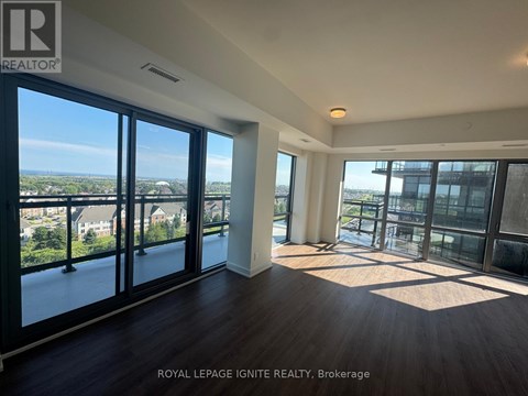 A spacious room with a view of the cityscape through large windows.