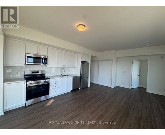 A kitchen with white cabinets and a stainless steel oven.