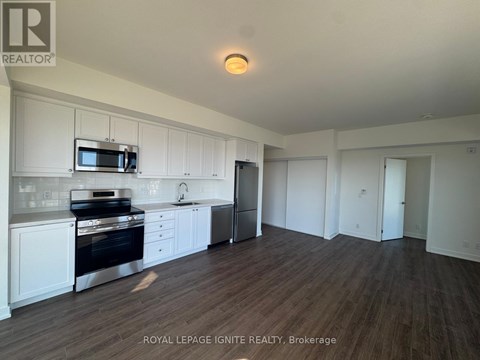 A kitchen with white cabinets and a stainless steel oven.