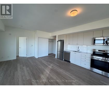 A kitchen with white cabinets and a stainless steel refrigerator.