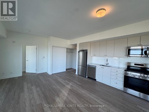 A kitchen with white cabinets and a stainless steel refrigerator.