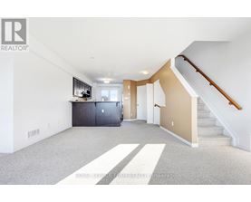 A spacious room with a staircase leading to the upper floor.