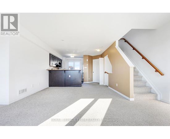 A spacious room with a staircase leading to the upper floor.