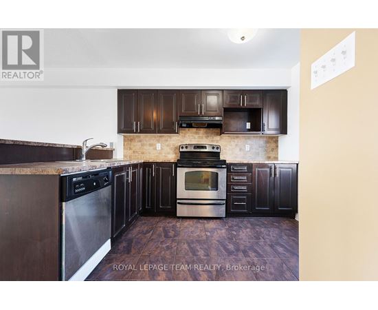 A kitchen with dark wood cabinets and stainless steel appliances.