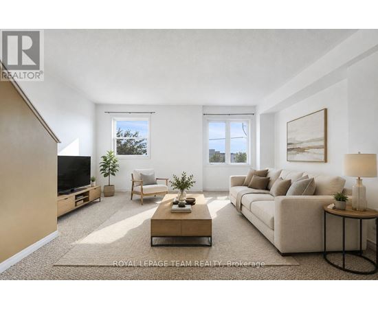 A well-lit living room with a beige sofa, a wooden coffee table, and a flat-screen TV.